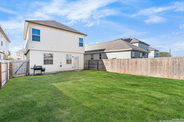 back of house featuring a lawn