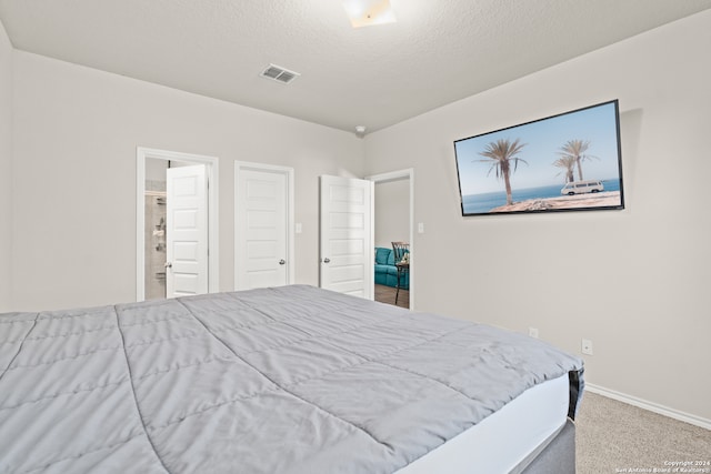 carpeted bedroom featuring a textured ceiling