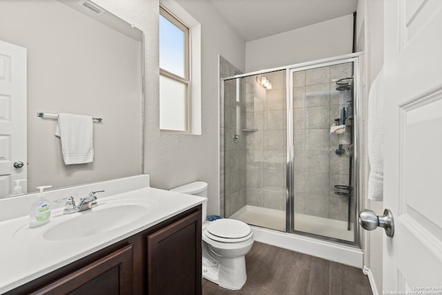 bathroom with toilet, a shower with door, vanity, and hardwood / wood-style flooring