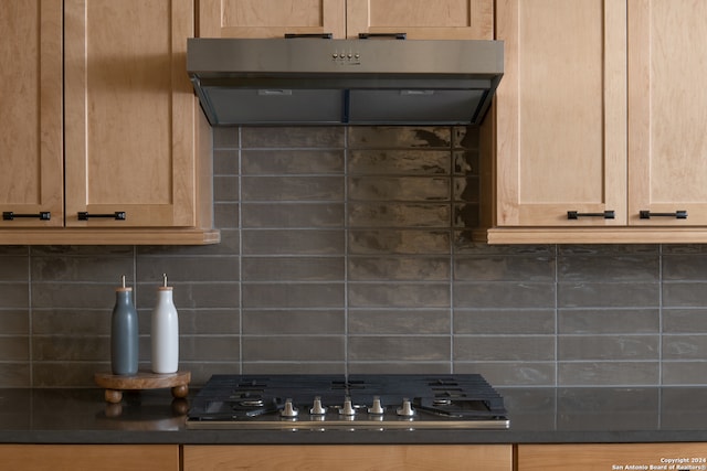 kitchen featuring light brown cabinets, tasteful backsplash, stainless steel gas cooktop, and range hood