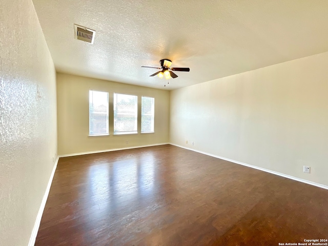 spare room featuring ceiling fan, dark hardwood / wood-style flooring, and a textured ceiling