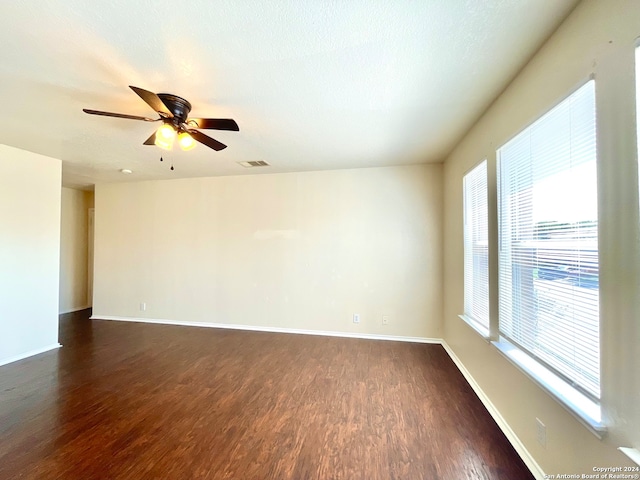 empty room featuring ceiling fan, dark hardwood / wood-style flooring, and a textured ceiling