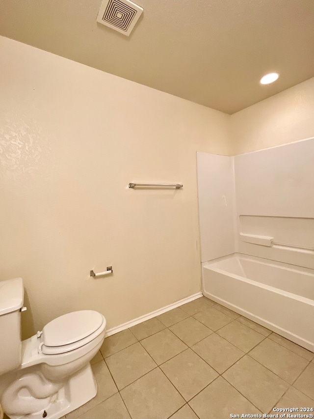 bathroom with tile patterned floors, shower / bathing tub combination, and toilet