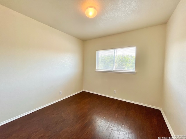 unfurnished room featuring dark hardwood / wood-style flooring