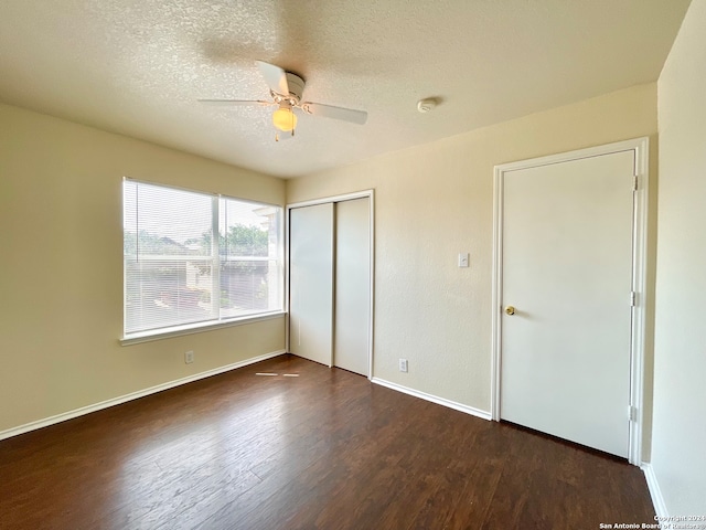 unfurnished bedroom with dark hardwood / wood-style floors, ceiling fan, a textured ceiling, and a closet