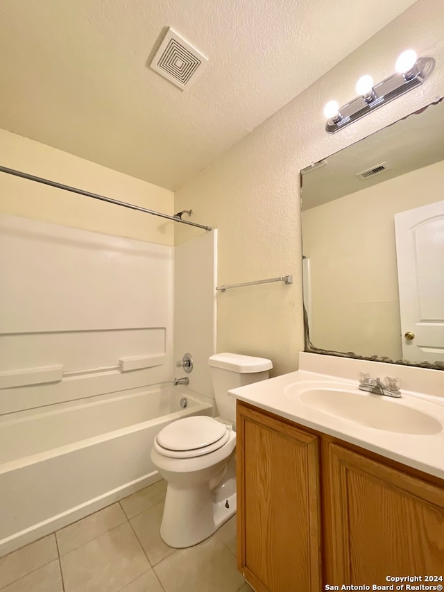 full bathroom with tile patterned floors, a textured ceiling, toilet, vanity, and bathtub / shower combination