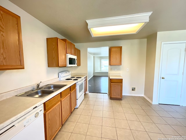 kitchen featuring light tile patterned flooring, white appliances, and sink