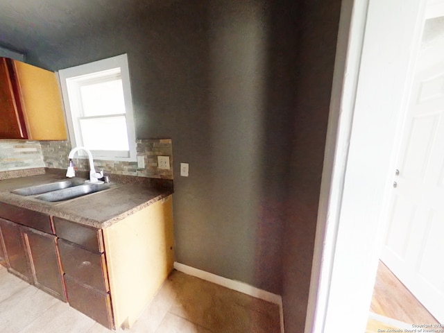 kitchen with light tile patterned flooring, sink, and backsplash