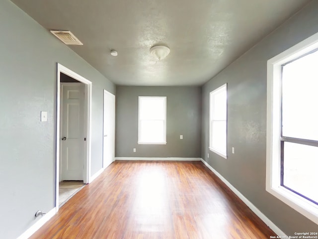 unfurnished room with wood-type flooring and plenty of natural light