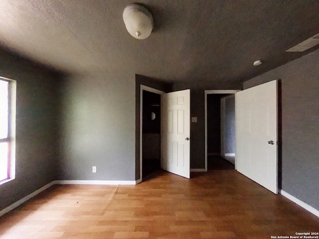 unfurnished bedroom featuring hardwood / wood-style floors and a textured ceiling