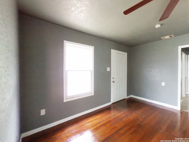 empty room with ceiling fan and dark wood-type flooring