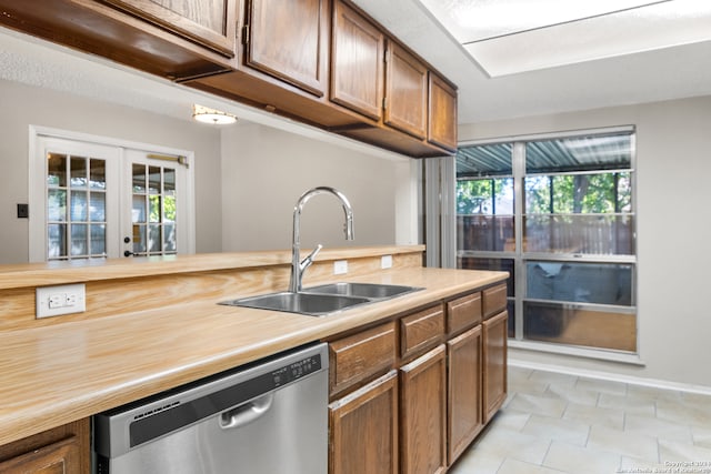 kitchen with dishwasher, a healthy amount of sunlight, french doors, and sink