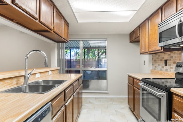 kitchen featuring decorative backsplash, sink, and stainless steel appliances