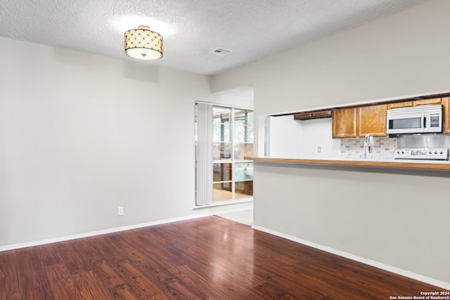 unfurnished living room with hardwood / wood-style floors and a textured ceiling