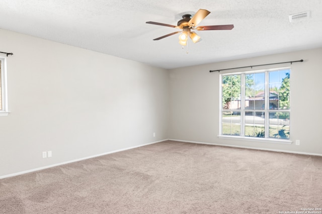 spare room featuring ceiling fan, carpet floors, and a textured ceiling