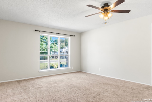 empty room featuring ceiling fan, carpet floors, and a textured ceiling