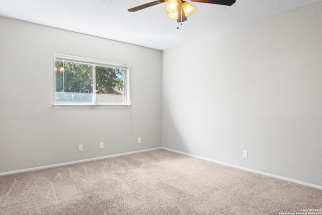 carpeted spare room with ceiling fan and a textured ceiling