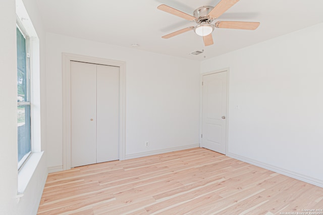 unfurnished bedroom with ceiling fan, light hardwood / wood-style floors, and a closet