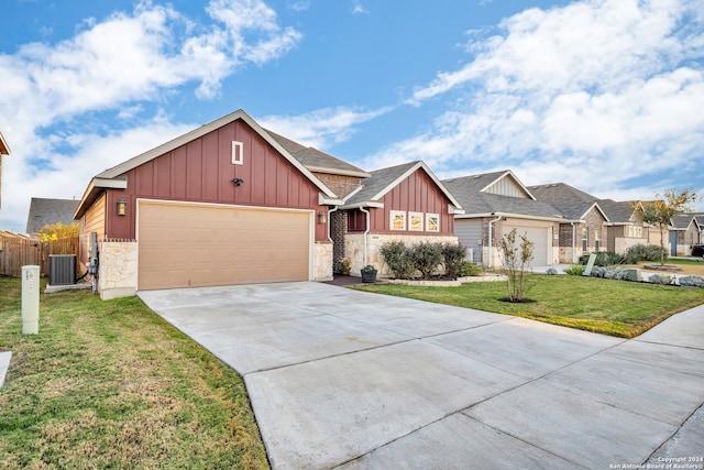 view of front of property featuring central AC, a front yard, and a garage