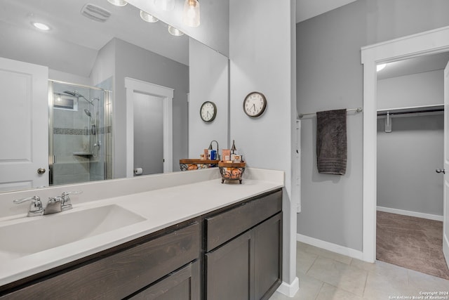 bathroom featuring tile patterned floors, a shower with door, and vanity