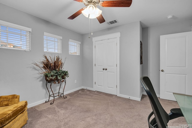 carpeted office space featuring ceiling fan