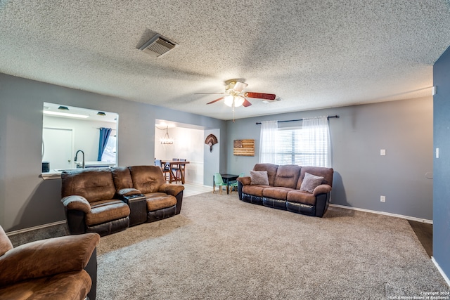 living room with a textured ceiling, carpet floors, and ceiling fan