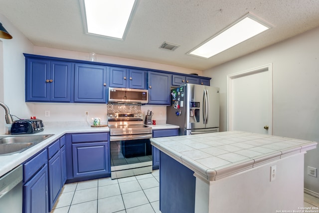 kitchen featuring a center island, stainless steel appliances, blue cabinets, and sink