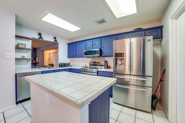 kitchen with blue cabinetry, a center island, stainless steel appliances, and sink