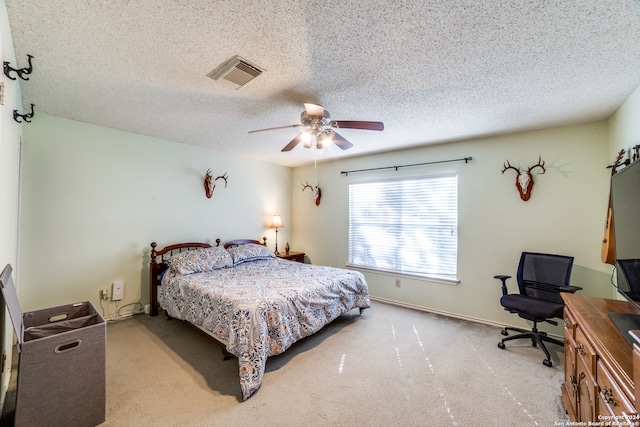 carpeted bedroom featuring ceiling fan and a textured ceiling