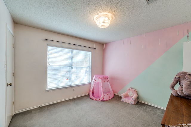 rec room with carpet and a textured ceiling