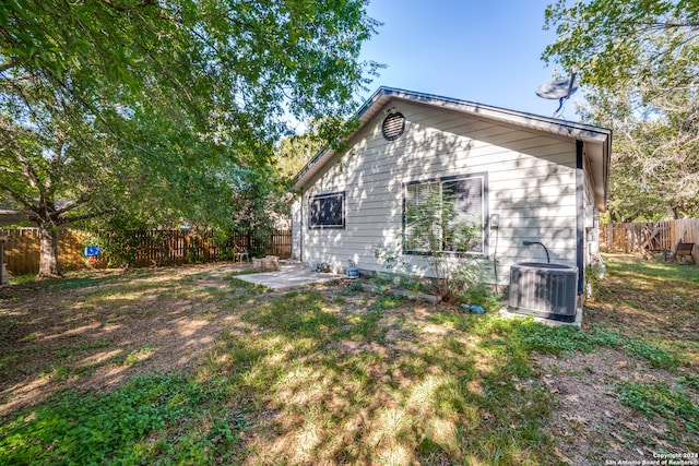 back of property featuring central air condition unit, a patio area, and a lawn