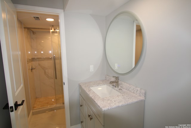 bathroom featuring tile patterned flooring, vanity, and walk in shower