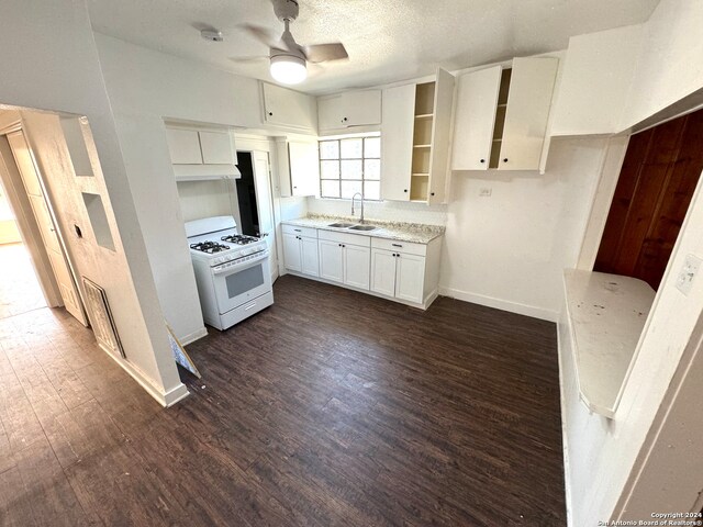 kitchen with white cabinets, sink, ceiling fan, dark hardwood / wood-style flooring, and white range with gas cooktop