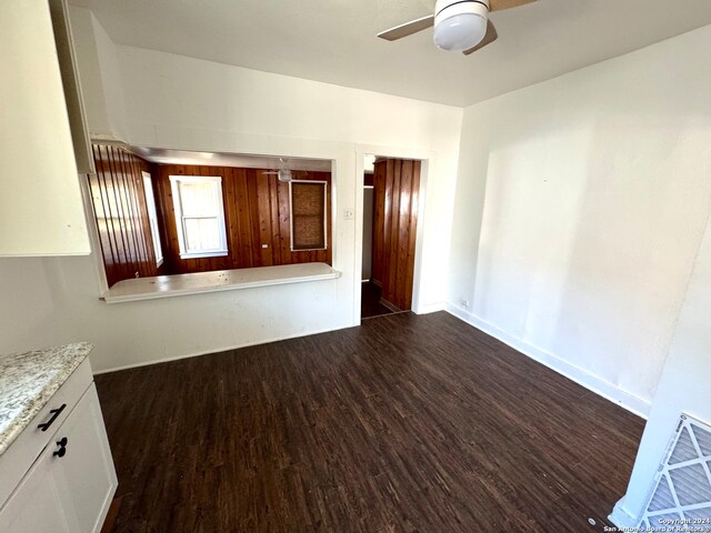 unfurnished living room featuring dark hardwood / wood-style flooring and ceiling fan