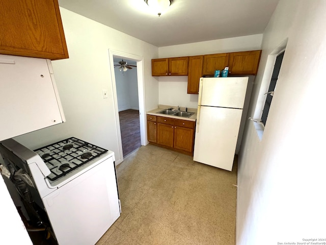 kitchen featuring white appliances, ceiling fan, and sink