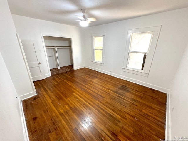 unfurnished bedroom with ceiling fan, dark hardwood / wood-style flooring, and a closet