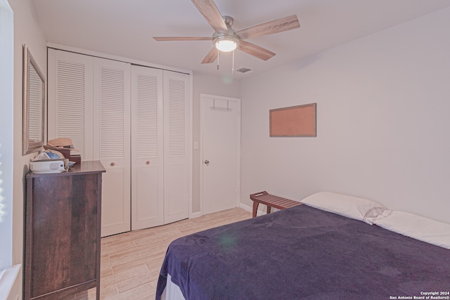 bedroom with ceiling fan, a closet, and light hardwood / wood-style floors