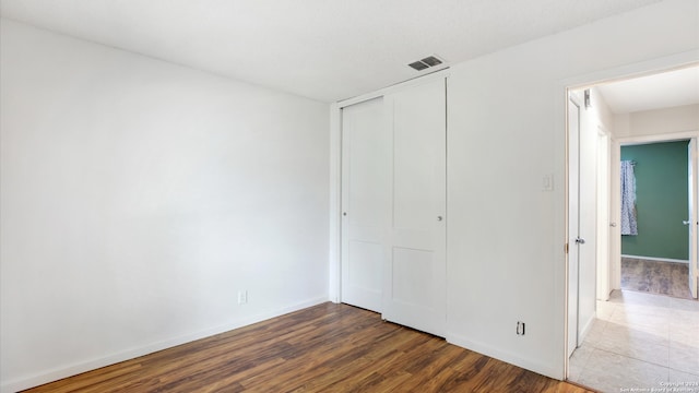 unfurnished bedroom with a closet and wood-type flooring