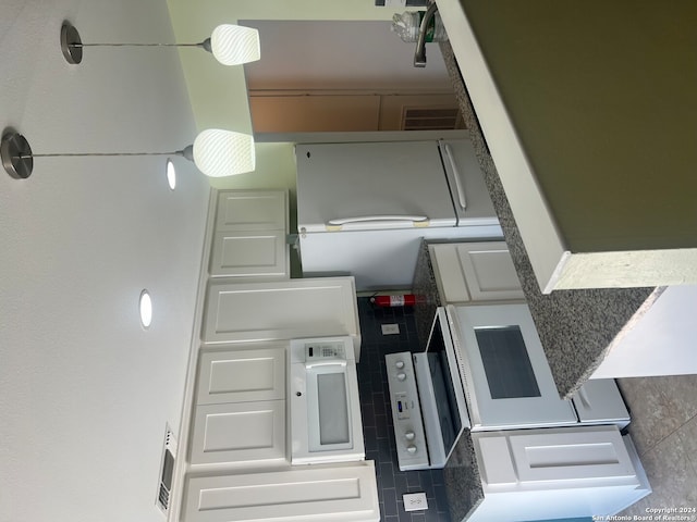 kitchen with tasteful backsplash and white cabinetry