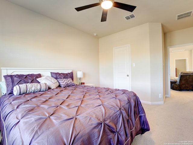 bedroom featuring ceiling fan, light carpet, and vaulted ceiling