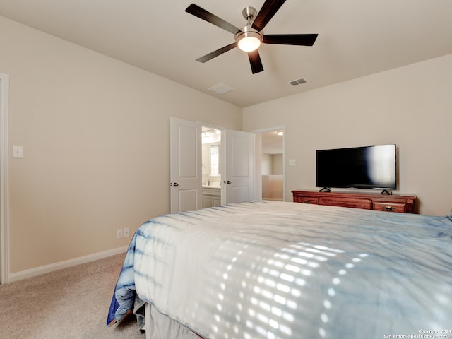 carpeted bedroom with ceiling fan and ensuite bathroom