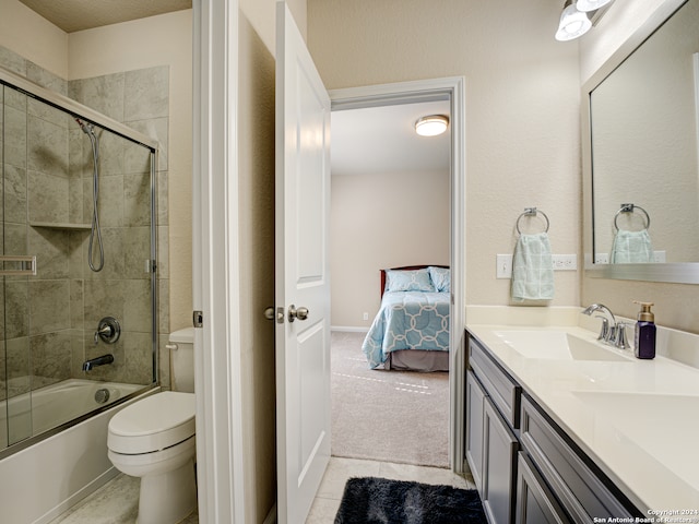 full bathroom featuring tile patterned flooring, vanity, toilet, and bath / shower combo with glass door