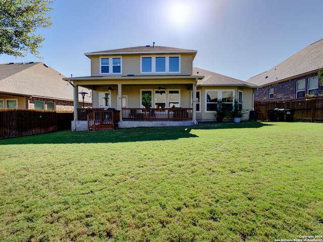 back of property with ceiling fan and a lawn