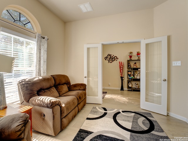 living room featuring lofted ceiling and french doors