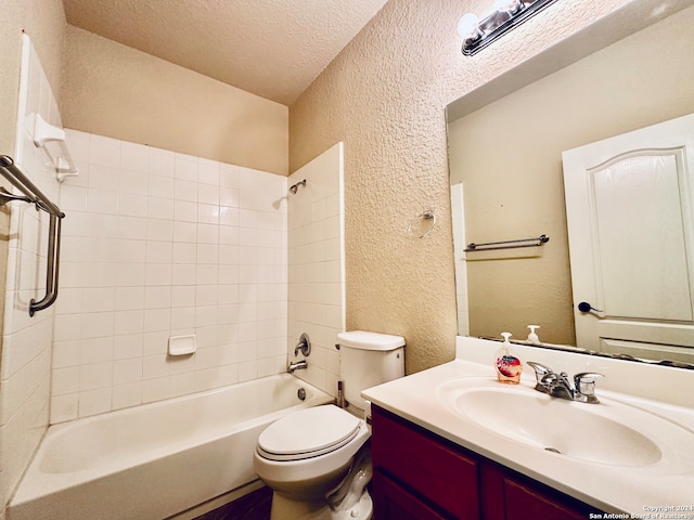 full bathroom featuring vanity, toilet, a textured ceiling, and tiled shower / bath