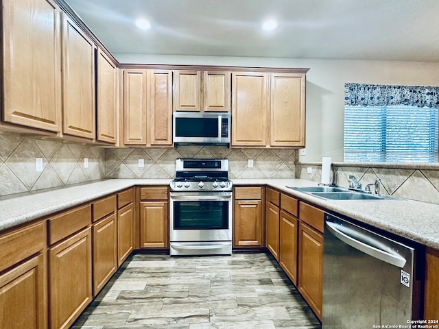 kitchen featuring backsplash, sink, and appliances with stainless steel finishes