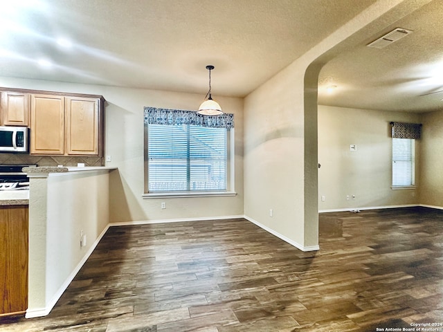 kitchen with range with electric stovetop, a textured ceiling, tasteful backsplash, decorative light fixtures, and dark hardwood / wood-style flooring