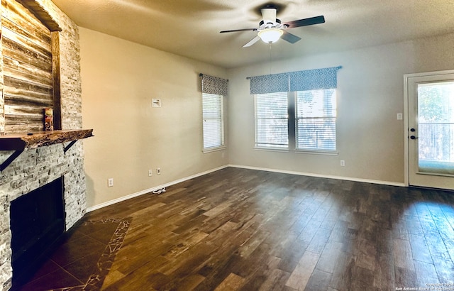 unfurnished living room with a fireplace, dark hardwood / wood-style flooring, and ceiling fan