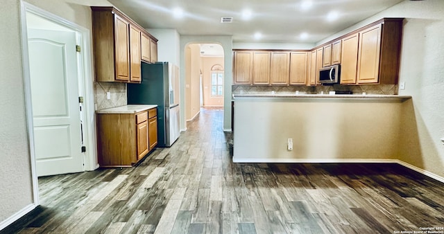 kitchen with decorative backsplash, dark hardwood / wood-style flooring, and stainless steel appliances