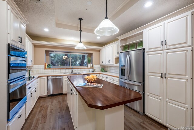 kitchen featuring butcher block countertops, a center island, white cabinetry, and stainless steel appliances